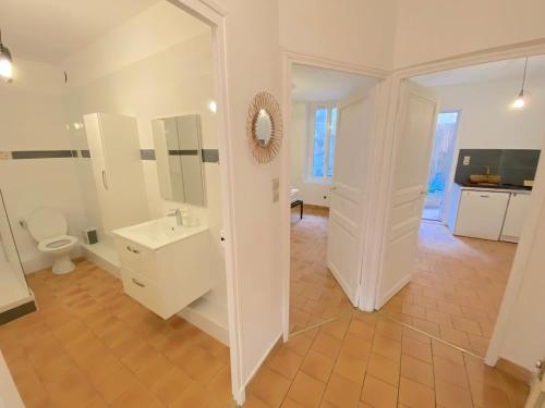 une salle de bain blanche avec un lavabo et des toilettes dans l'établissement Grand T3 à 20 mètres du port, à Sanary-sur-Mer