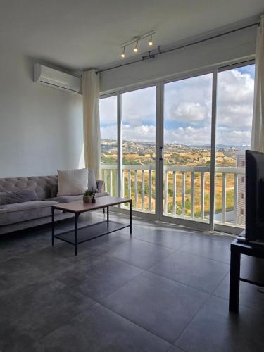 a living room with a couch and a large window at Studio by The Sea in Limassol