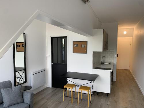 une cuisine et un salon avec une table et des chaises dans l'établissement Les clarines, appartement de standing, à Les Minimes