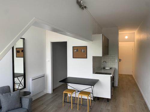 une cuisine et un salon avec une table et des chaises dans l'établissement Les clarines, appartement de standing, à Les Minimes