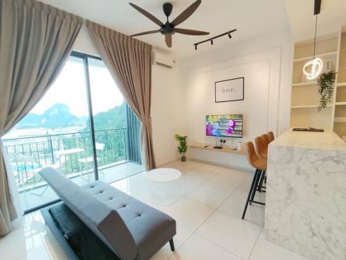 a living room with a couch and a large window at Ipoh Sunway Onsen Suites and Tambun Guesthouse , 3-14pax 2parking by IWH in Ipoh