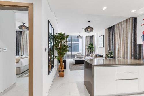 eine Küche und ein Wohnzimmer mit weißen Wänden in der Unterkunft Luxurious 1 BR in District One Beach Access in Dubai