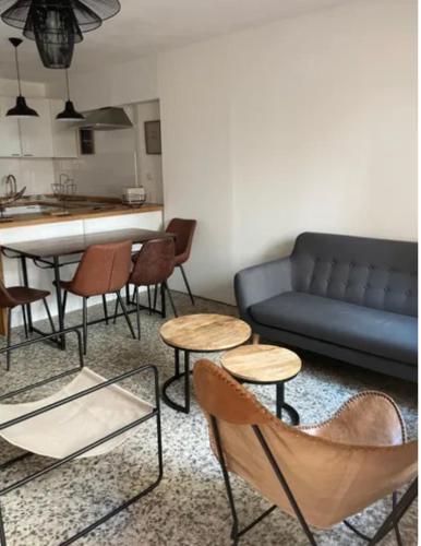 un salon avec un canapé bleu et des chaises dans l'établissement Maisonnette centre Béziers, à Béziers