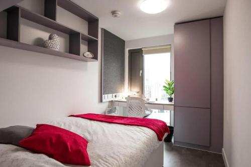 a bedroom with a bed with a red blanket on it at Paradise Village Coventry in Coventry