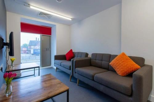 a living room with a couch and a table at Paradise Village Coventry in Coventry