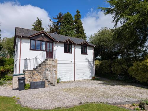 a white house with a white garage at Near Eden Project apartment in Trethurgy
