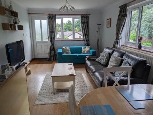 a living room with a couch and a table at Near Eden Project apartment in Trethurgy
