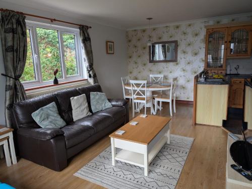 a living room with a couch and a table at Near Eden Project apartment in Trethurgy