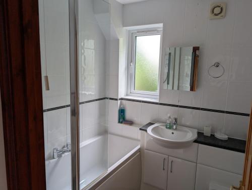 a bathroom with a shower and a sink and a tub at Near Eden Project apartment in Trethurgy