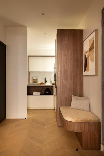 un salon avec un banc et une cuisine dans l'établissement Elegant apartment - 2BR- 6P- Gare Saint Lazare, à Paris