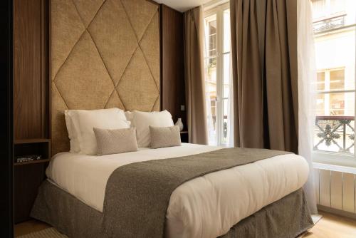 une chambre avec un grand lit et une fenêtre dans l'établissement Elegant apartment - 2BR- 6P- Gare Saint Lazare, à Paris