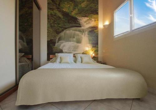 une chambre avec un grand lit avec une fresque en cascade dans l'établissement Le Zenith - Calme absolu, jardin et piscine en Provence, à LʼIsle-sur-la-Sorgue