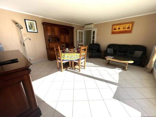 un salon avec une table et un canapé dans l'établissement Appartement vue mer à la semaine uniquement, à Saint-Aygulf