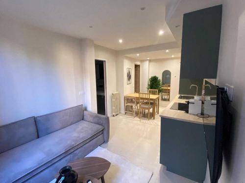 un salon avec un canapé et une cuisine avec une table dans l'établissement Modern apartment -2BDR 6P - 300m from the BEACH, à Antibes