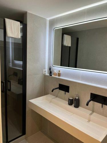 une salle de bain avec un lavabo et un miroir dans l'établissement Modern apartment -2BDR 6P - 300m from the BEACH, à Antibes