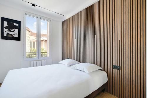 une chambre avec un lit blanc et une grande fenêtre dans l'établissement Charming Appt - 1BDR 4P - Saint Ouen, à Saint-Ouen