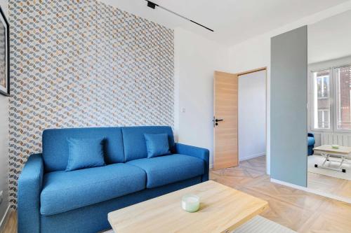 un salon avec un canapé bleu et une table dans l'établissement Charming Appt - 1BDR 4P - Saint Ouen, à Saint-Ouen