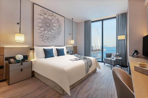 a hotel room with a large bed and a desk at Address Beach Resort in Dubai