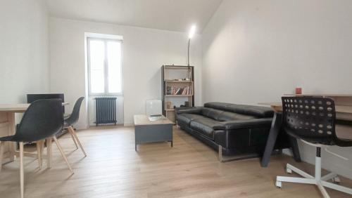 - un salon avec un canapé et des fauteuils en cuir noir dans l'établissement Maison cosy avec jardin – Centre de Poitiers, à Poitiers