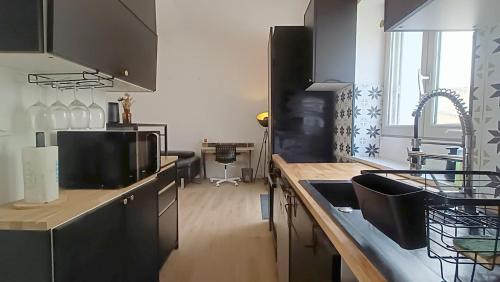 une cuisine avec un évier et un plan de travail dans l'établissement Maison cosy avec jardin – Centre de Poitiers, à Poitiers
