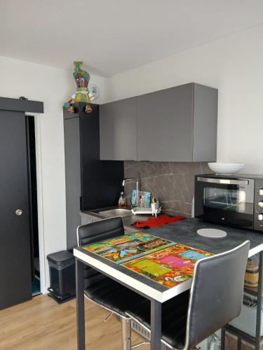 une cuisine avec une table recouverte d'une nappe dans l'établissement La P'tite Créole, à Auzon