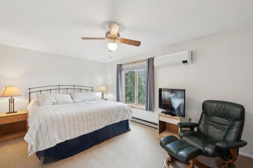 a bedroom with a bed and a chair and a television at Sagamore 46G - Adirondack Retreat for All Seasons in North Creek