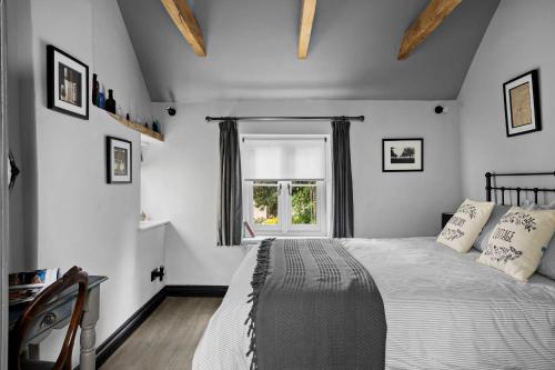 a bedroom with a large bed and a window at Apothecary Cottage - Pet Friendly Wedmore Couples Cottage - Free WiFi - Free Parking in Wedmore