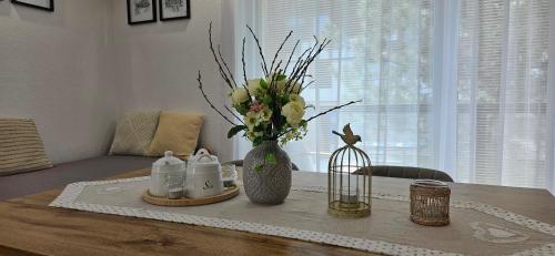 a table with a vase of flowers in a room at Apartment Beauty Tatry with a view of the mountains in Nová Lesná