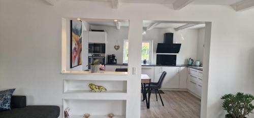a kitchen and a living room with a table at Cozy Villa in Rødby