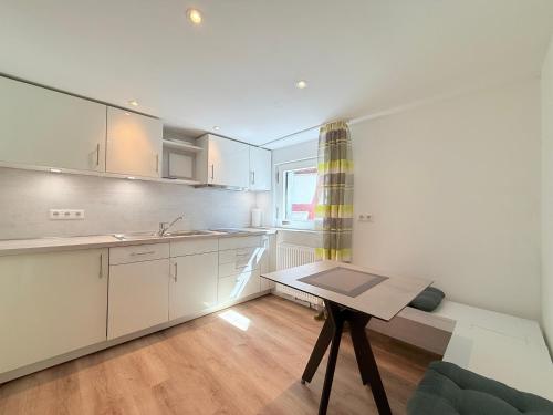 a kitchen with white cabinets and a table and a window at Linzgau in Sipplingen