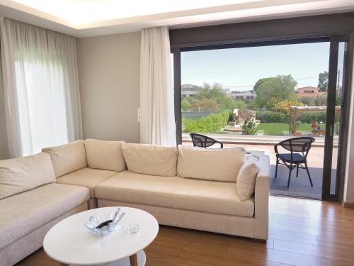 a living room with a couch and a table at Peaceful Maisonette near Rafina in Pikérmion