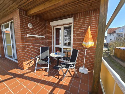 a patio with two chairs and a table and an umbrella at Haus Kim - Apartments in Waren