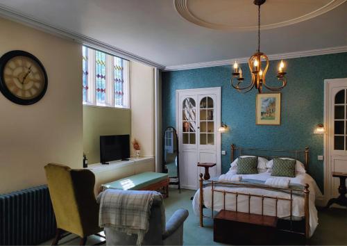 a bedroom with a bed and a clock on the wall at The Hall - Historic Grade I-listed Jacobean Mansion in Bradford on Avon
