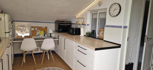 a kitchen with white cabinets and a clock on the wall at Casa D’Amelia in Ojén