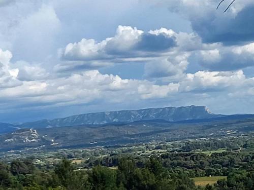 - une vue sur une vallée avec des montagnes sous un ciel nuageux dans l'établissement Les Cigales, à Villelaure