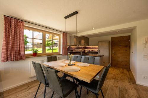 a kitchen and dining room with a wooden table and chairs at Holzhof in Breitnau