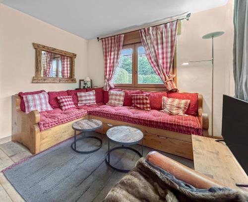 - un salon avec un canapé rouge et 2 tables dans l'établissement Appartement cosy T3 avec Terrasse, Jardin & Garage, à Megève