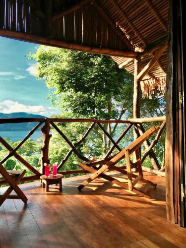 a porch with a table and a view of the ocean at Makako Lodge in Ampangorinana
