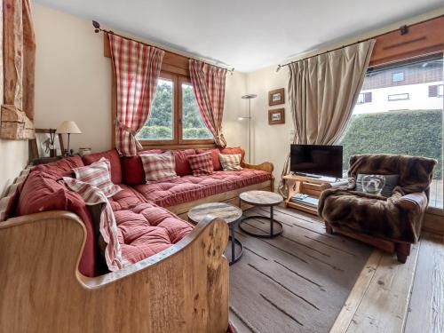 un salon avec un canapé rouge et une télévision dans l'établissement Appartement cosy T3 avec Terrasse, Jardin & Garage, à Megève