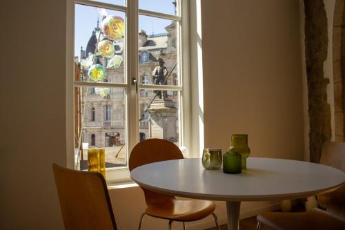 une table et des chaises devant une fenêtre dans l'établissement Suite George - 4 pers proche du coeur historique, à Charleville-Mézières