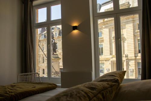 une chambre avec un lit et une grande fenêtre dans l'établissement Suite George - 4 pers proche du coeur historique, à Charleville-Mézières