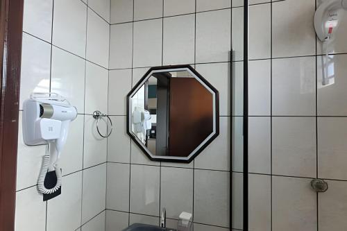 a mirror on the wall of a bathroom with a phone at AP102 - Apartamento com AC no centro in São Miguel dʼOeste