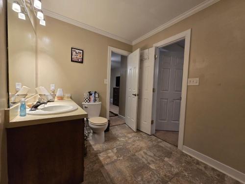 a bathroom with a toilet and a sink and a mirror at Serenity Haven in Lillington
