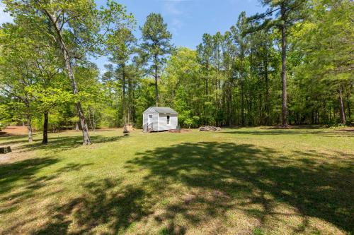 a white shed in the middle of a field with trees at Serenity Haven in Lillington