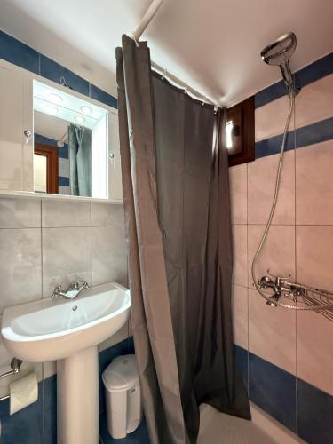 a bathroom with a sink and a shower at Meltemi Beach Apartment in Mochlos