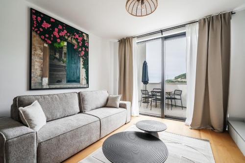a living room with a couch and a table at Vuelo Sobre by In Property in Becici
