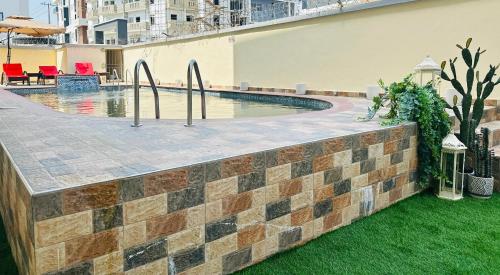 una pared de ladrillo junto a la piscina en Gemmes Apartment, en Lekki