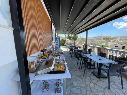 a breakfast buffet on a balcony with tables and chairs at Summer Dreams in Ksamil