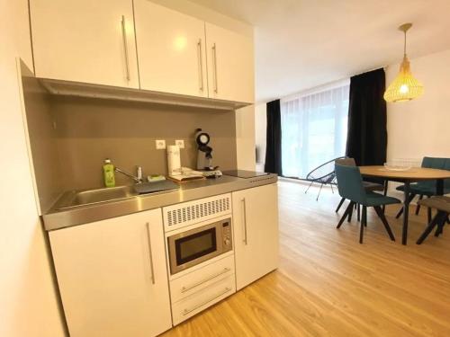 a kitchen with a sink and a table with chairs at Ferien & Business Apartments Hohenfels in Hohenfels
