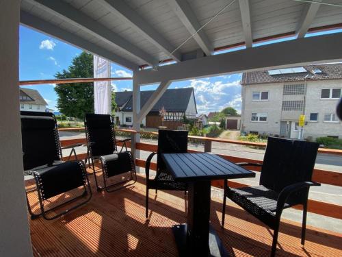 a patio with a table and chairs on a deck at Ferien & Business Apartments Hohenfels in Hohenfels